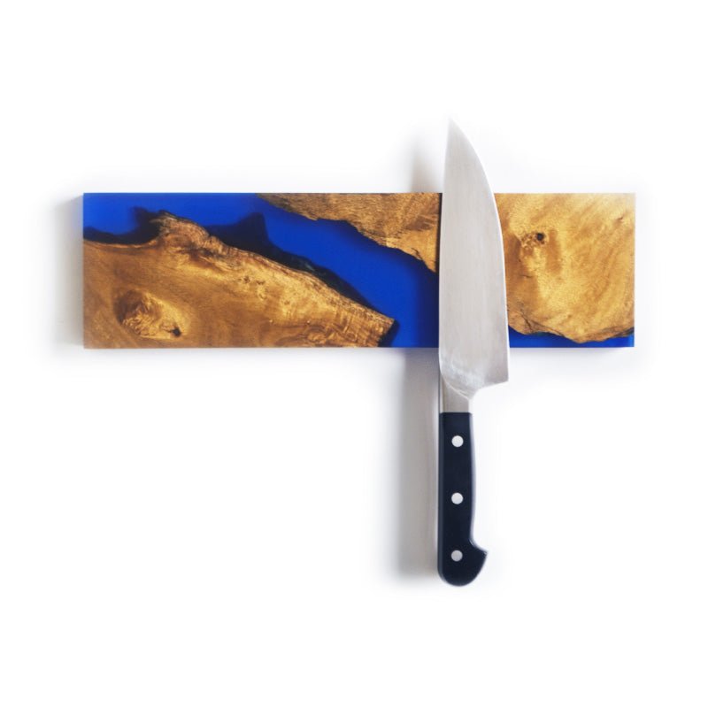Live edge epoxy river knife holder made from salvaged acacia, blue epoxy resin, and magnets. Used to store knives in the kitchen.
