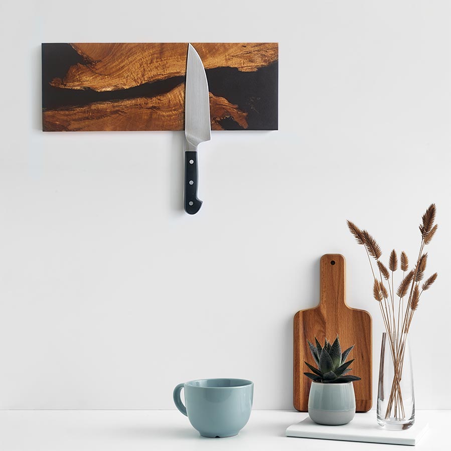 salvaged live edge acacia wood and black epoxy river magnetic knife rack holding a kitchen knife