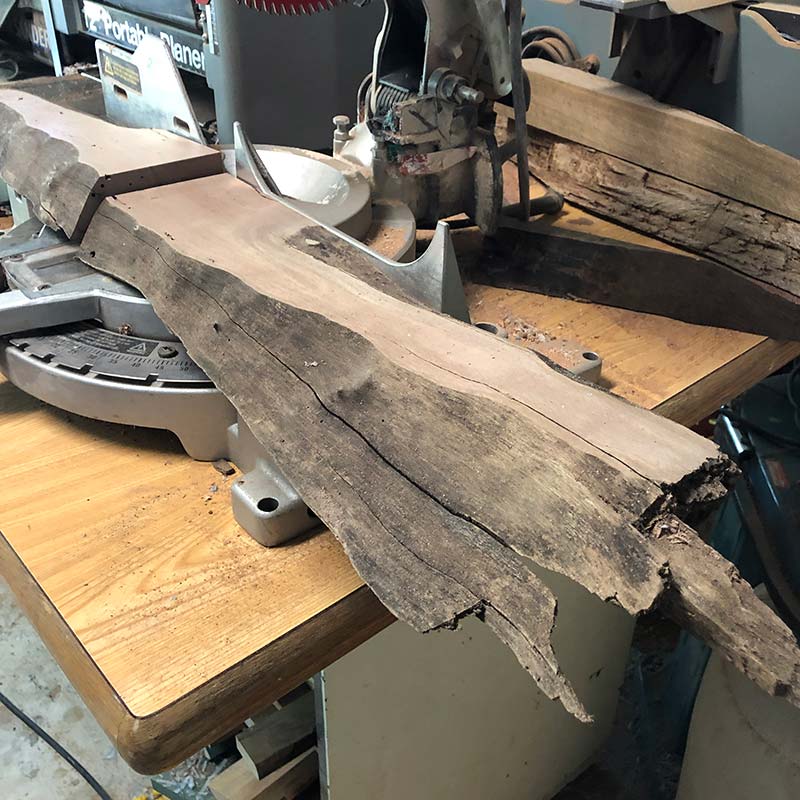 Using a miter saw to cut a live edge piece of salvaged lumber to make a real wood magentic knife strip
