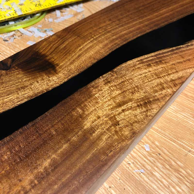 detailed close up view of a magnetic knife strip made with epoxy resin and live edge acacia wood