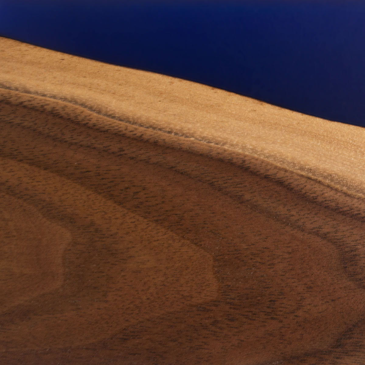 closeup detailed view of a black walnut live edge magnetic knife holder with sapphire blue epoxy