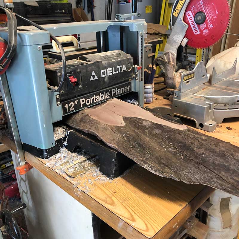 using a planer to flatten a live edge wood slab, the first step in the process of making a live edge and epoxy resin magnetic knife rack