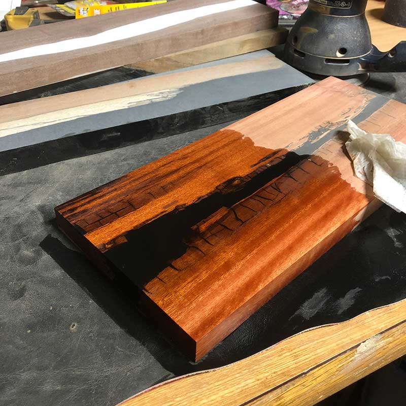 revealing the wood grain of a magnetic knife holder handcrafted with flamewood lumber and black epoxy resin