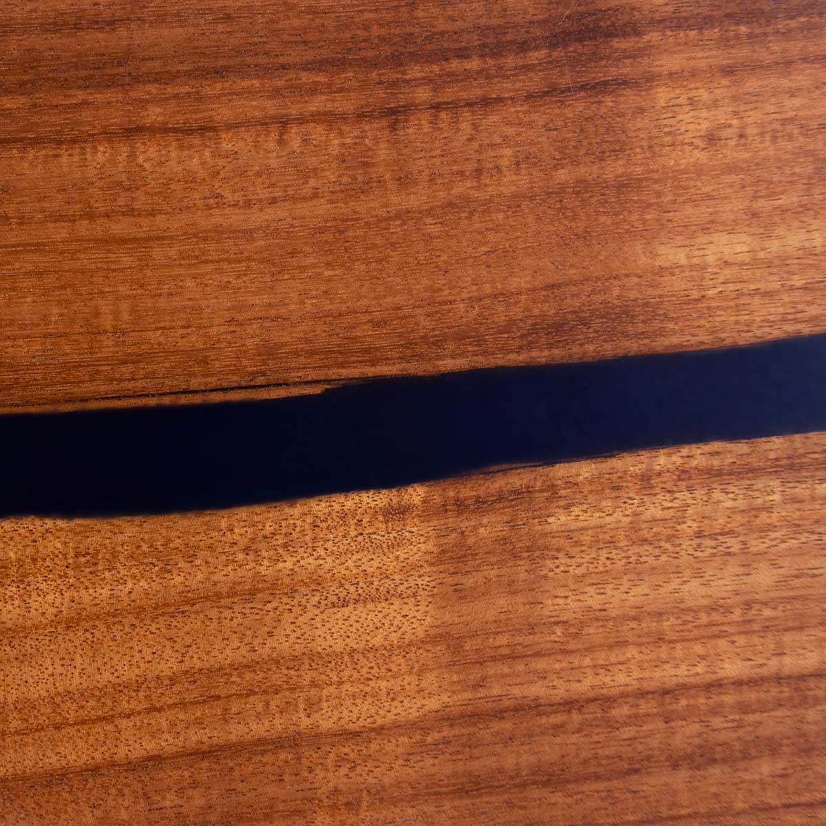 closeup detailed view of a sweet acacia magnetic knife holder made with live edge wood and blue epoxy resin