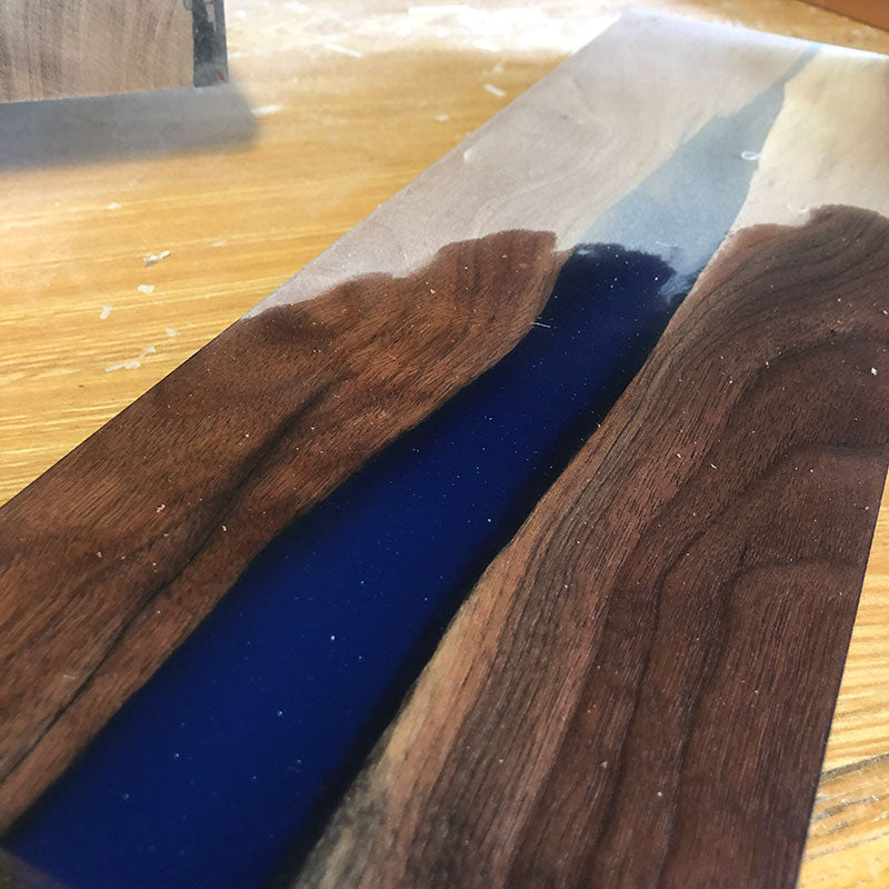 sanding a walnut hardwood and blue epoxy resin magnetic knife holder made from salvaged lumber