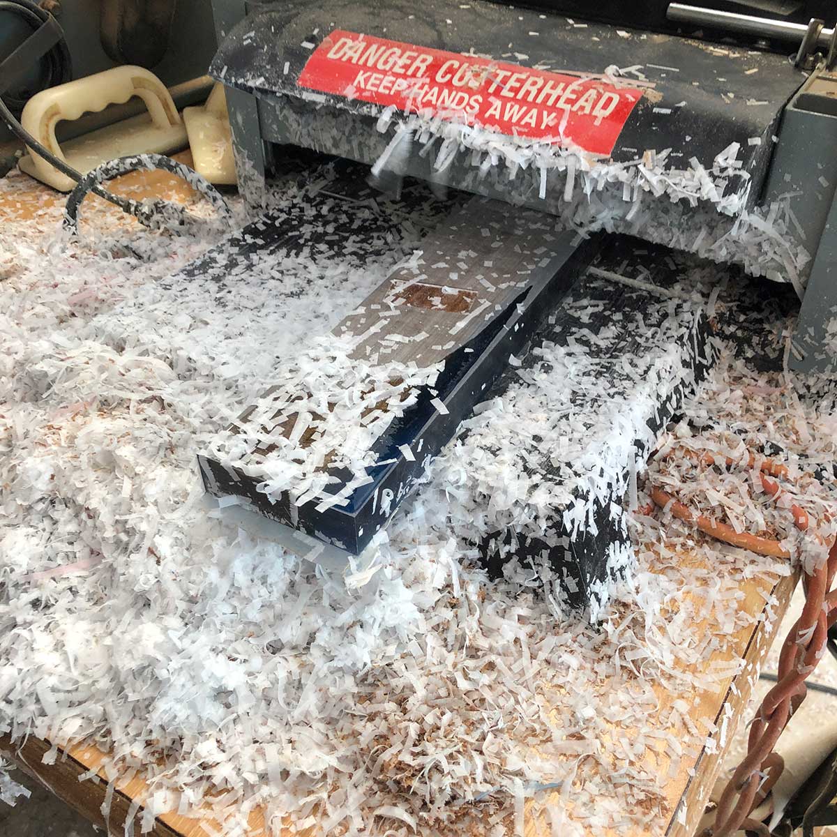 creating lots of epoxy resin shavings while flattening an acacia live edge and epoxy resin magnetic knife rack using a benchtop planer
