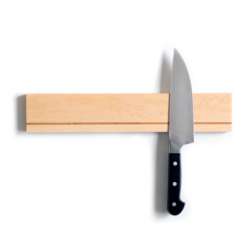 handmade wood magnetic knife holder crafted with maple and cherry holding a kitchen knife
